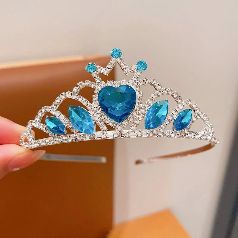 Children's metal headband with crystal crown design in pink, light blue, or light purple.
