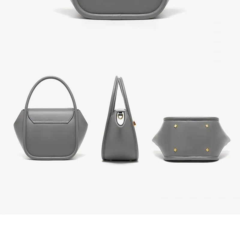 A wing-shaped women's leather tote bag with a buckle latch, shown in blue with a cross-body strap.