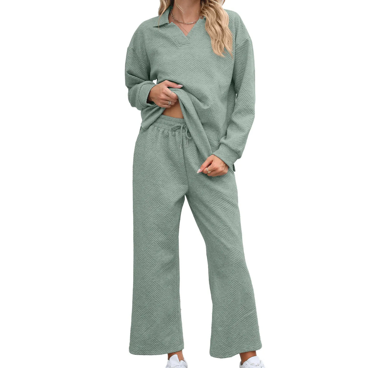 Women's solid colour knitted jacquard sweater and trousers co-ord suit on a hanger.
