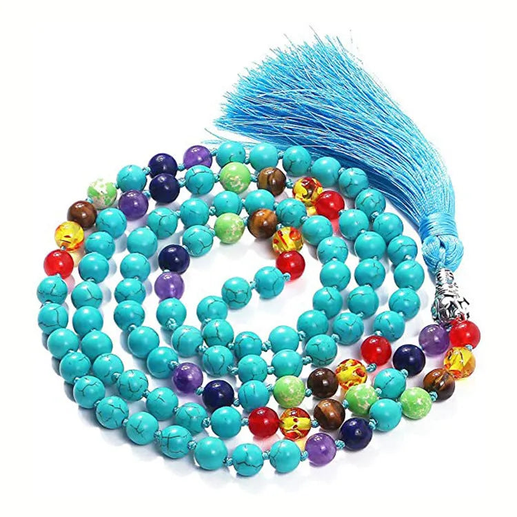 Long blue patterned agate and stone tassel necklace with geometric beads on a white background.