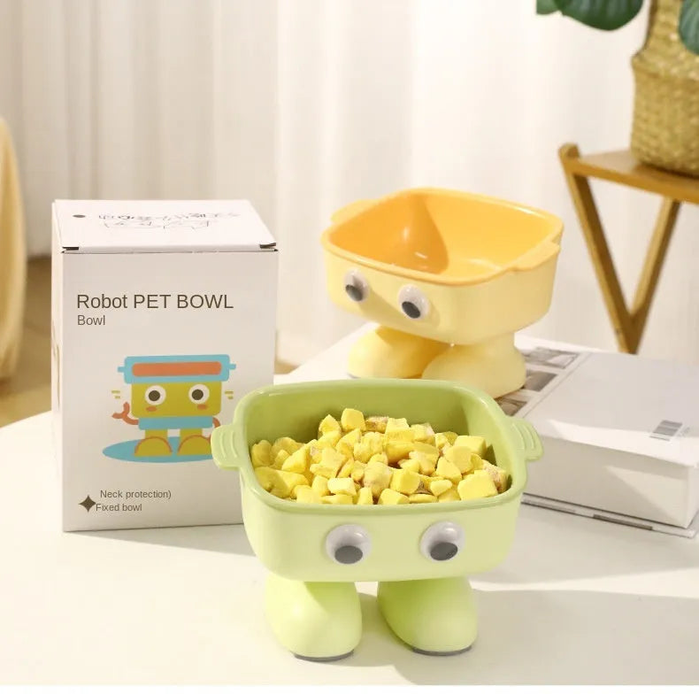 Green cartoon robot shaped elevated cat bowl with tilted food dish on anti-slip base