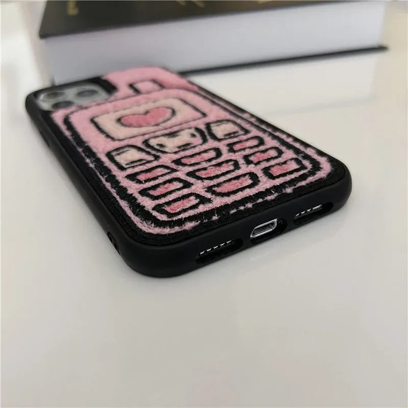 Pink iPhone case with a textured, towel-like embroidered design on the back.