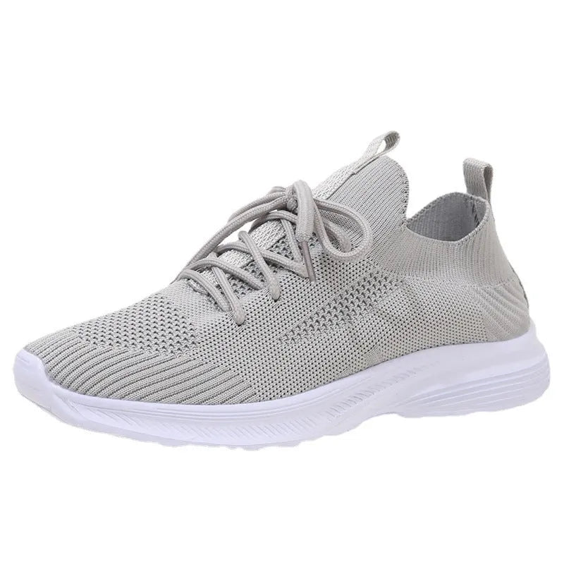 Women's low-top mesh running shoe in creamy white with a round toe and flat rubber sole.