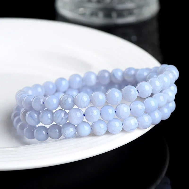Blue agate beaded bracelet with multi-circle patterns and Ruyi design elements on a wrist.