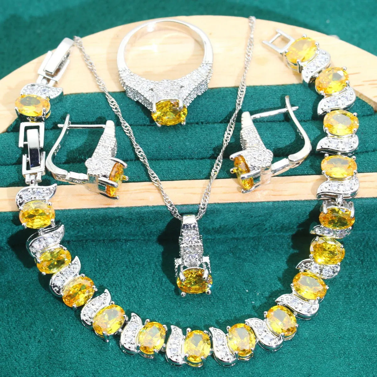 Four-piece bridal jewellery set showing alloy pendant necklace, bracelet, earrings, and ring on a white background.