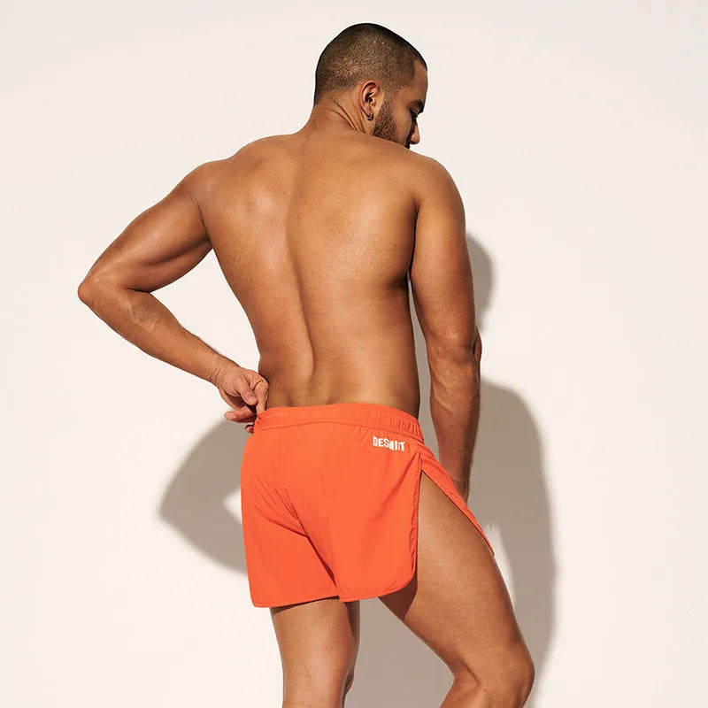 Men's loose orange red polyester beach trousers for surfing and swimming on a summer day.