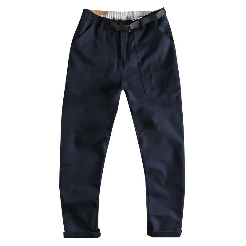 Men's khaki cotton work trousers with an N I buckle belt on a mid-rise waist.