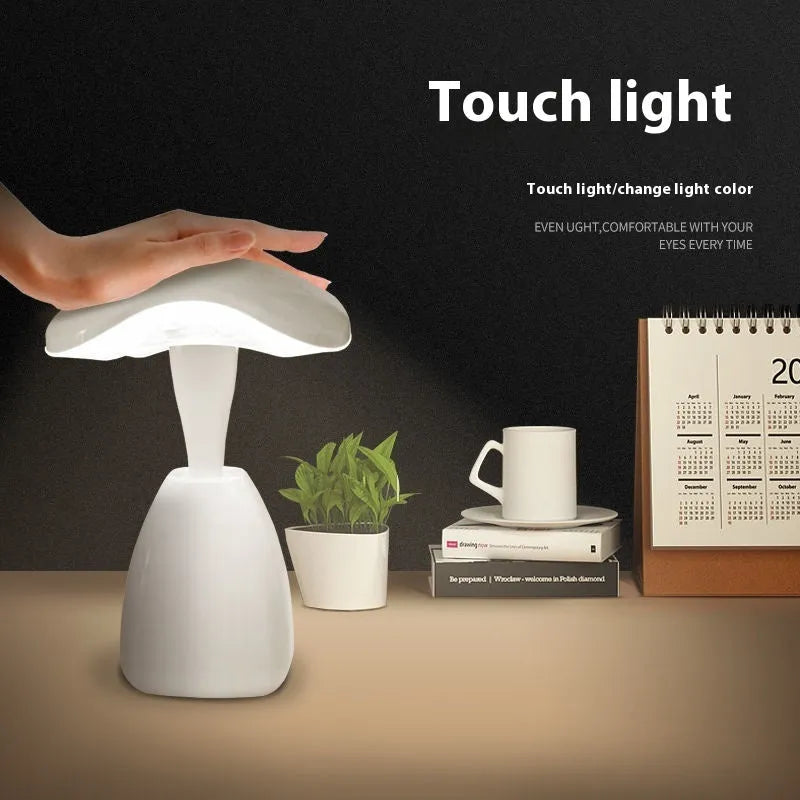 White modern LED desk lamp with a plastic shade and touch switch on a table.