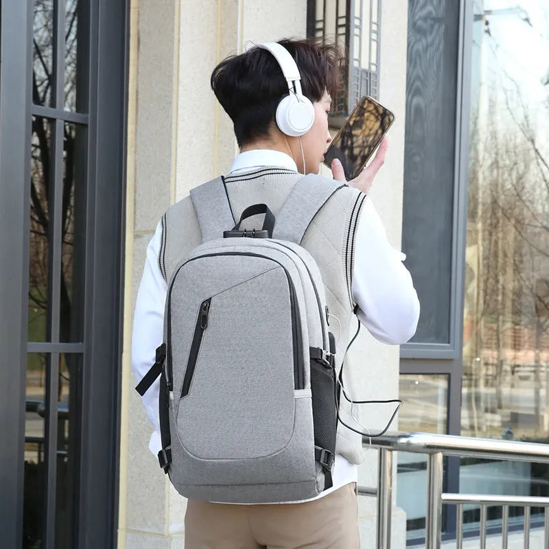 Grey Oxford cloth computer backpack for men on a table, showing front view and size.