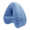 Heart-shaped dark blue memory foam leg pillow for adults on a bed.