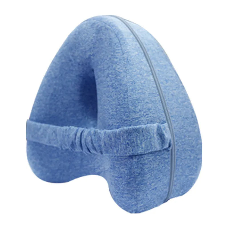 Heart-shaped dark blue memory foam leg pillow for adults on a bed.