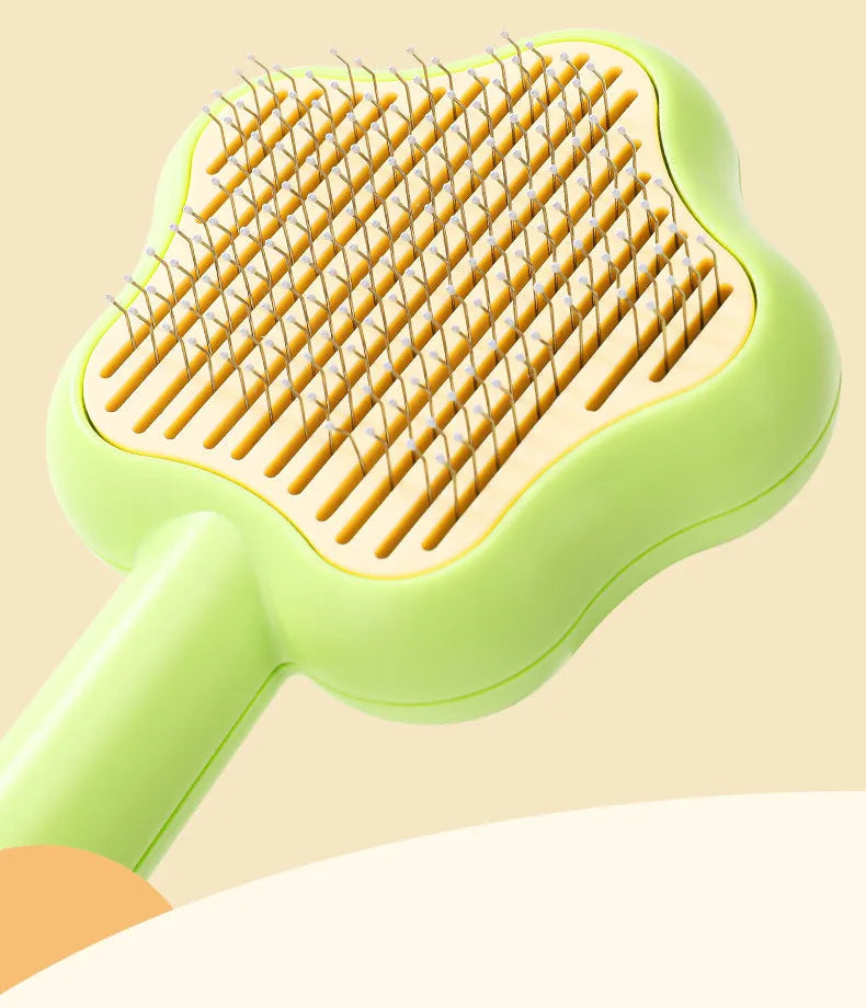 Green stainless steel cat comb with magic wand self-cleaning mechanism showing needle teeth and plastic handle