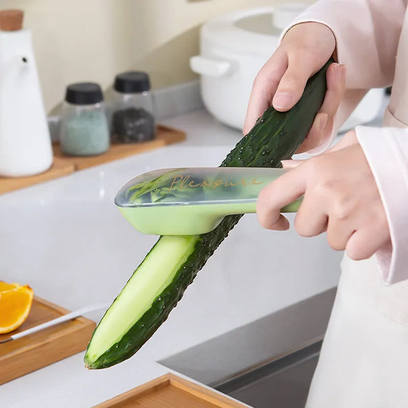 Dark green fruit vegetable peeler with storage tube showing stainless steel blade and hanging hole