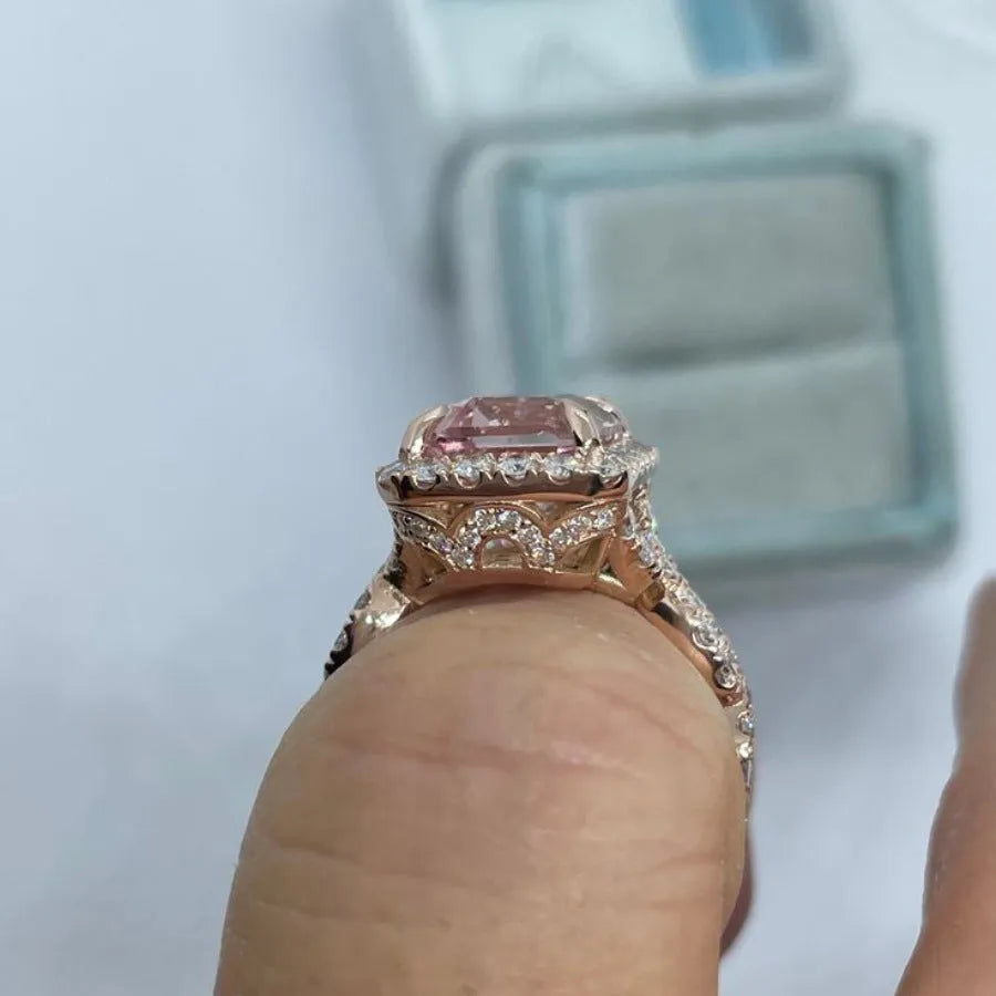 Geometric rose gold coloured alloy ring on a plain background.
