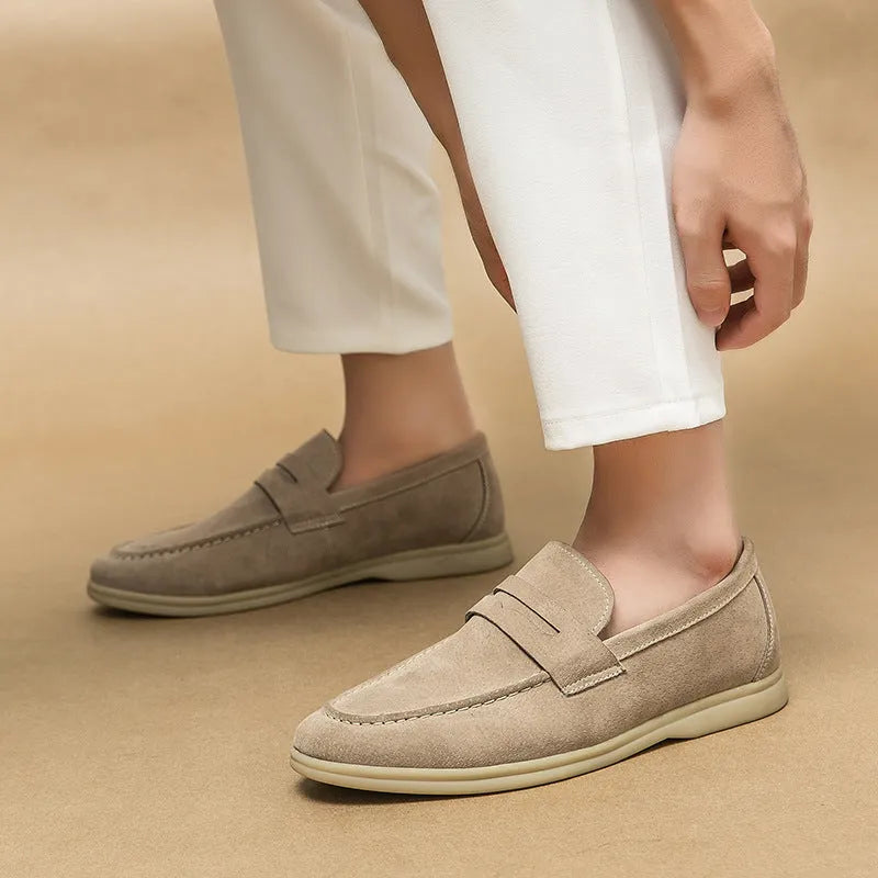 Men's beige leather slip-on casual shoes with a round toe and rubber sole on a neutral background.