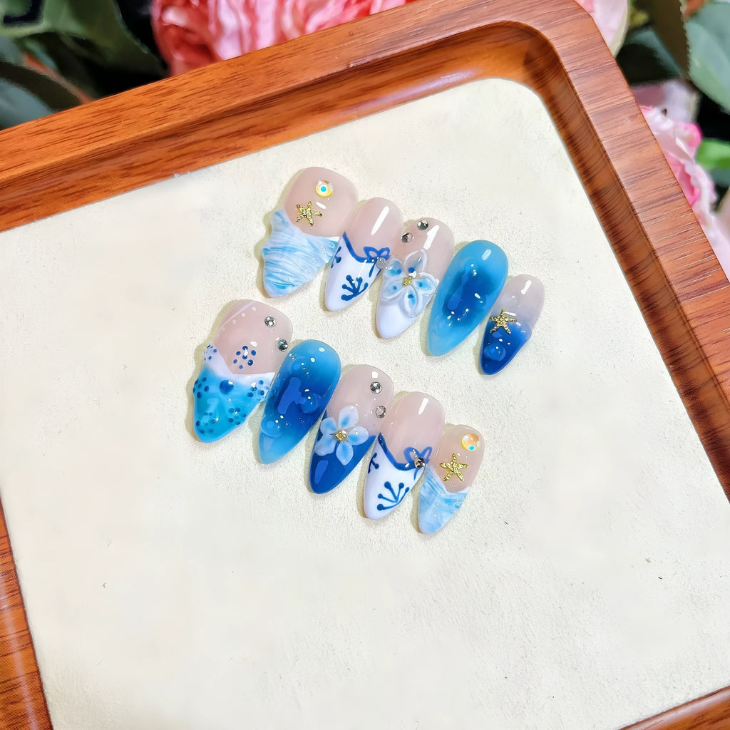 Set of blue hand-painted carved summer ice transparent plastic fake nails in sizes XS, S, M, L.
