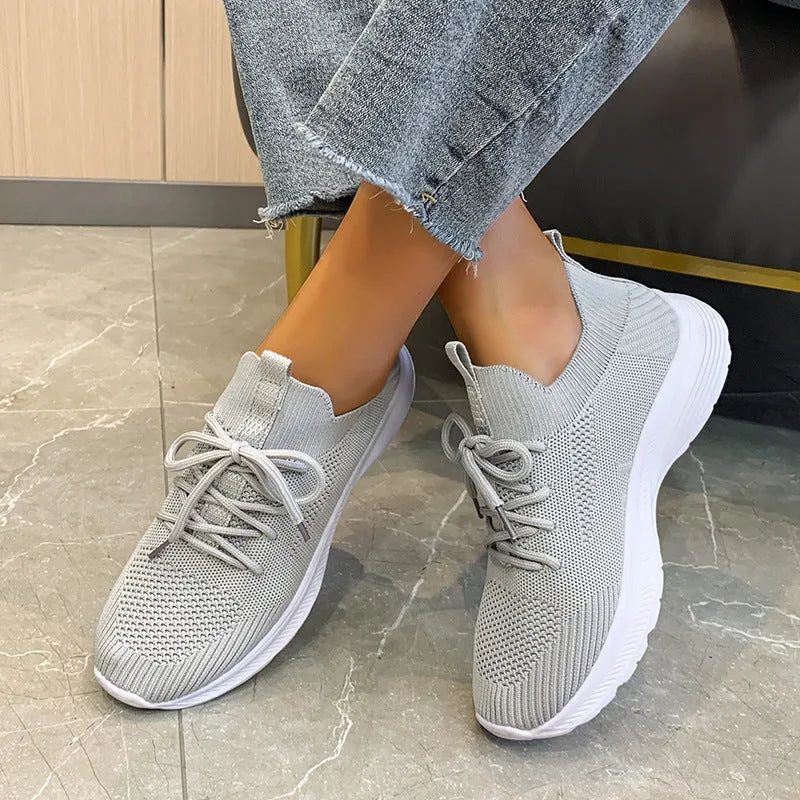 Women's low-top mesh running shoe in creamy white with a round toe and flat rubber sole.