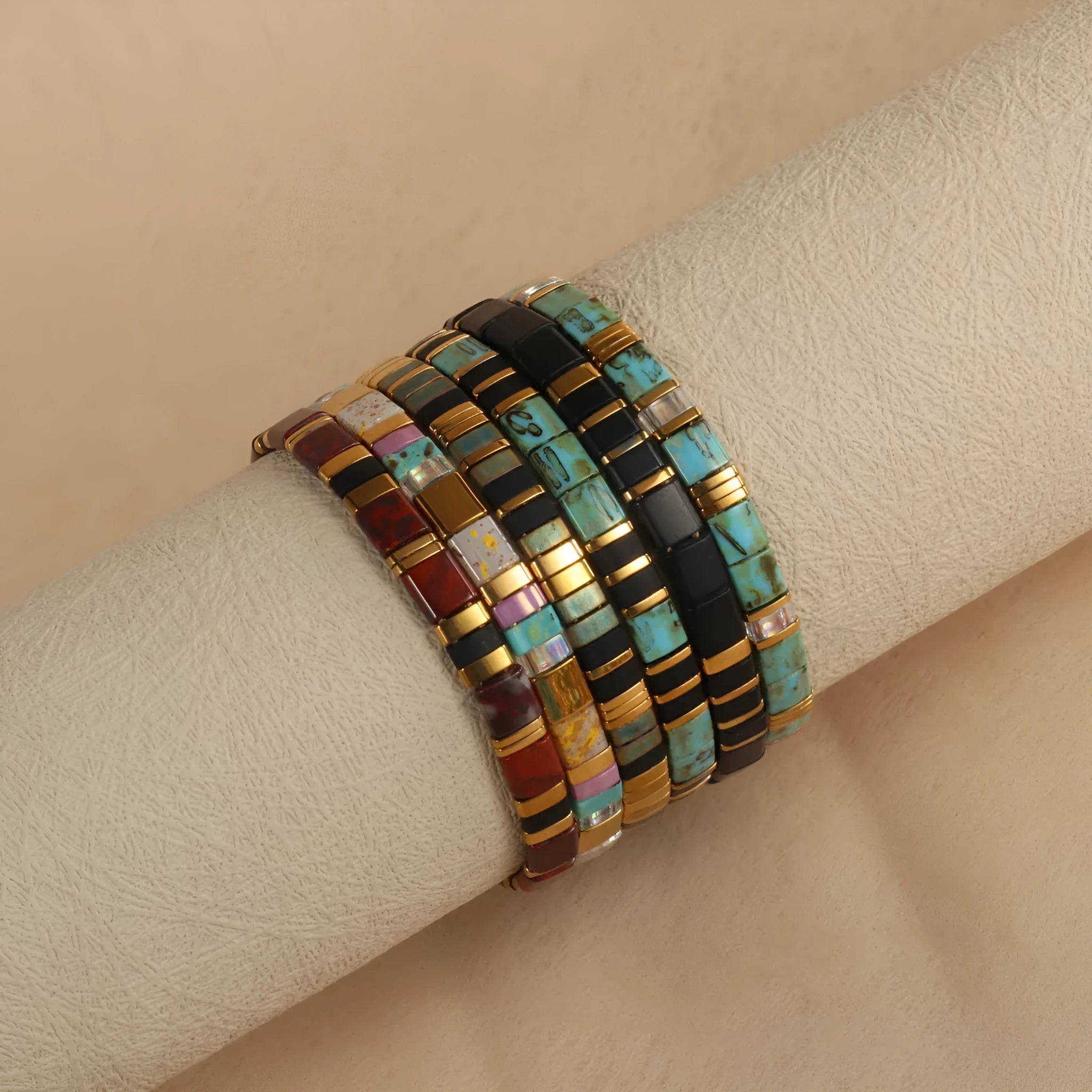 Geometric glass beaded bracelet in milky white, black, green, blue, or red on a white background.