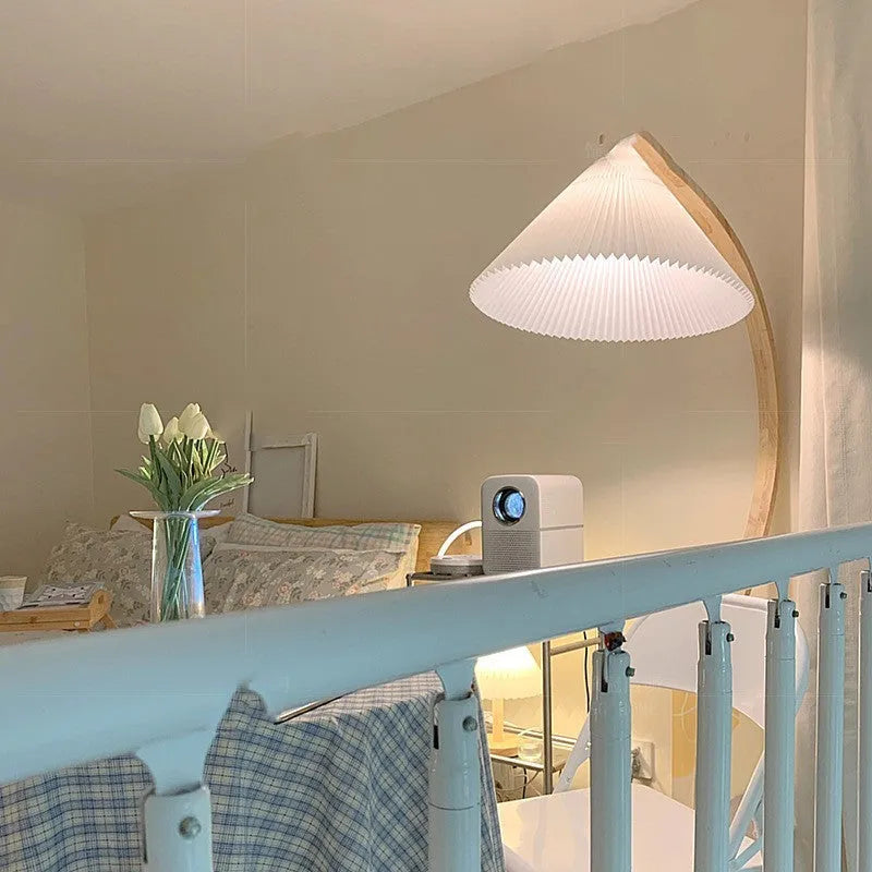 Retro-style vertical table lamp with log white lampshade placed on a sofa arm.