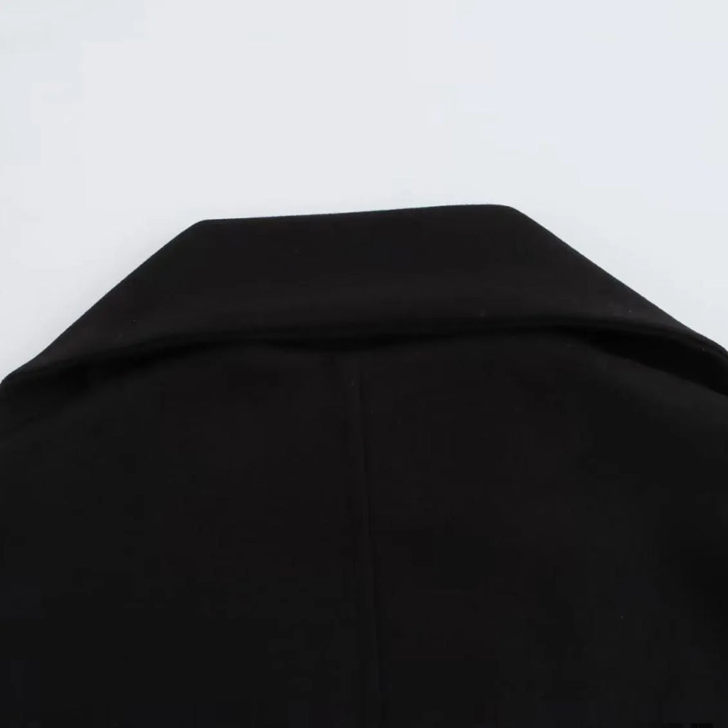 Women's long black polyester overcoat with artificial fur collar and pockets, showing extended length.