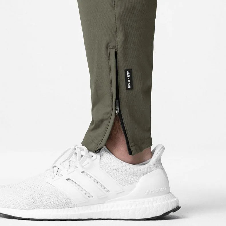 Man wearing loose grey ankle-tie fitness trousers suitable for running and gym workouts.