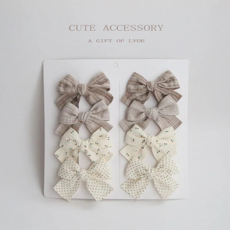 Set of children's cloth hair clips with a dovetail bow design in various colours.