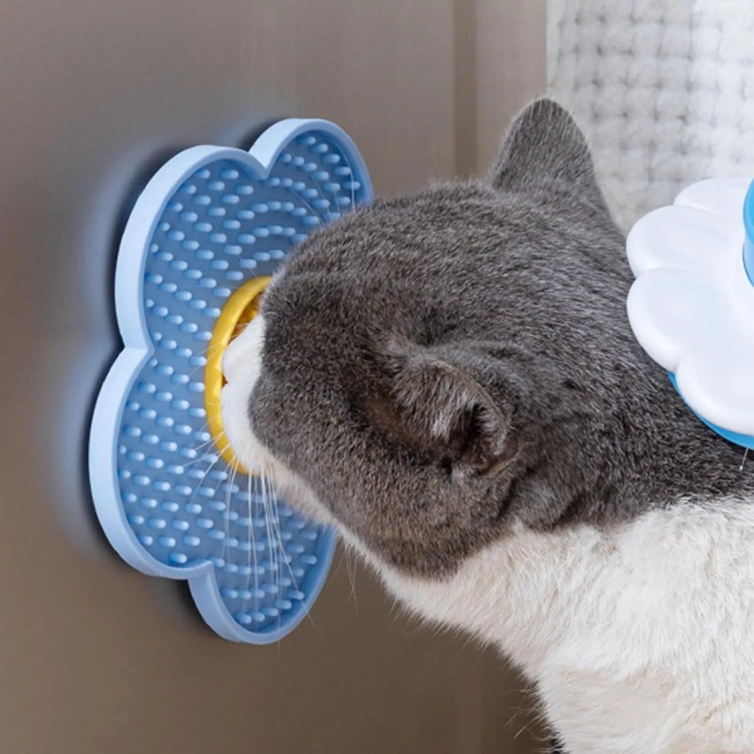 Flower-shaped blue silicone pet lick mat with suction cups on a tiled floor.