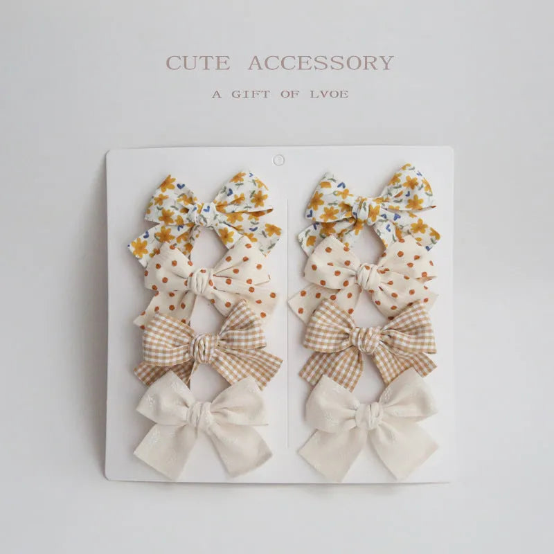 Set of children's cloth hair clips with a dovetail bow design in various colours.