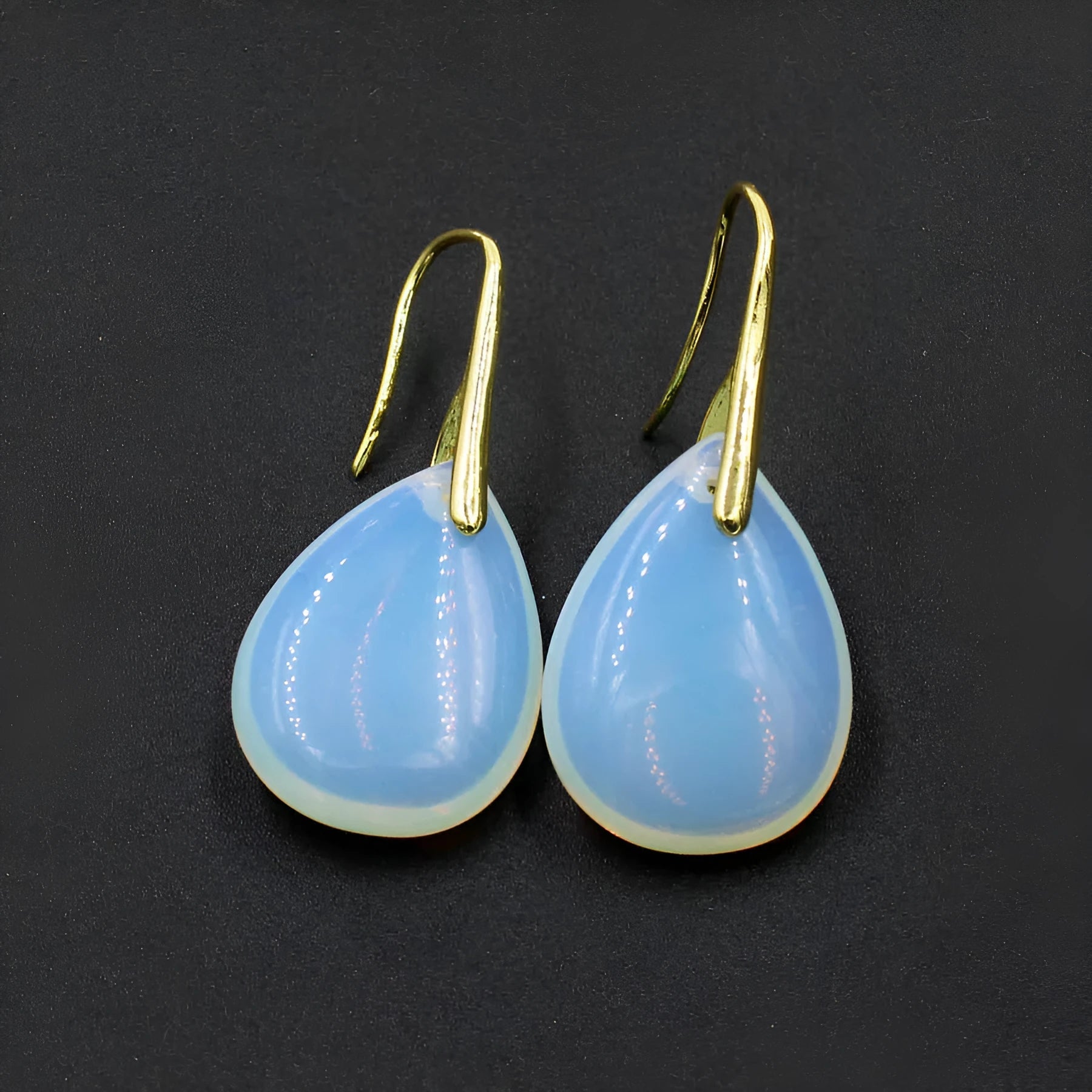 Geometric water drop shaped earrings made from genuine crystal in assorted colours with electroplated metal.