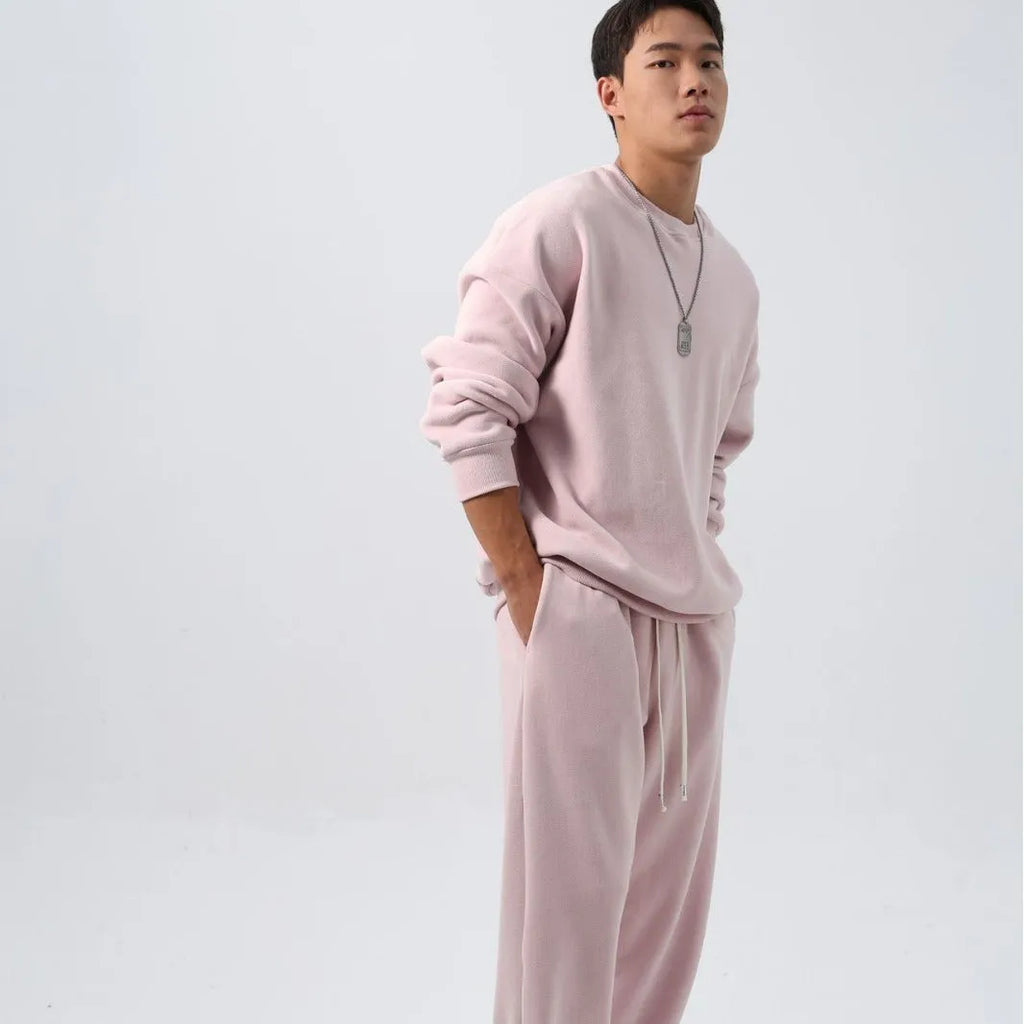 Men's black polar fleece sports suit with crew neck coat and padded trousers on a hanger