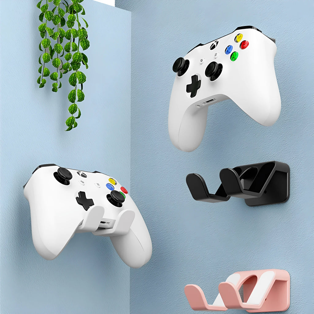Black universal X-shaped wall hanging rack for game controllers with adhesive backing.