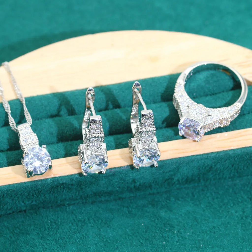 Four-piece bridal jewellery set showing alloy pendant necklace, bracelet, earrings, and ring on a white background.