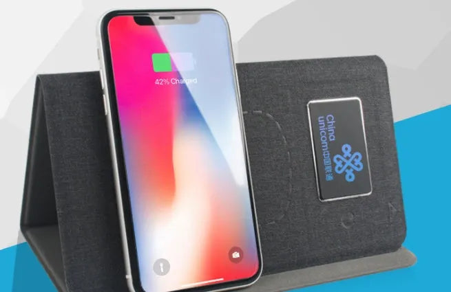 Folding wireless charging mouse pad set with separate Bluetooth mouse on a desk.