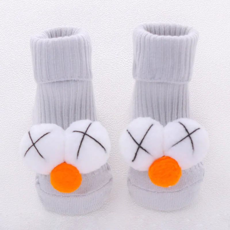 Cotton baby floor socks in a selection of colours and patterns like panda, lion, and bows, shown in sizes for infants.