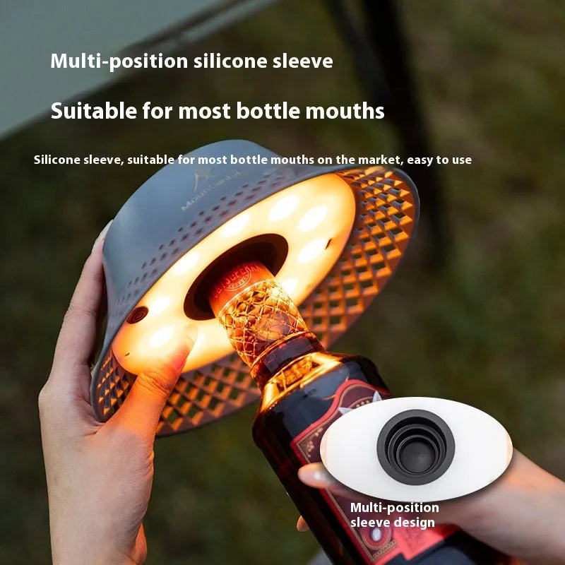 Beige wine bottle shaped camping lantern with USB-C port and adjustable light settings on a wooden table.