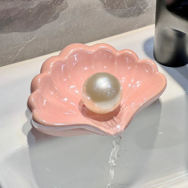 White plastic shell-shaped soap dish for bathroom countertop or wall.