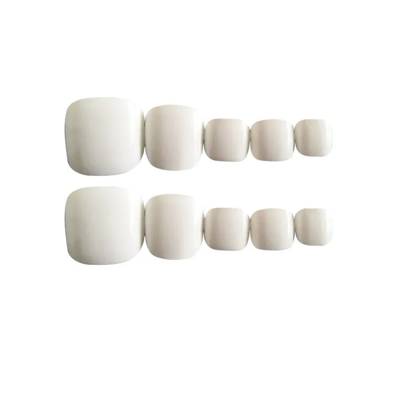 White false nail set with starry sky pattern and adhesive glue for at-home application.