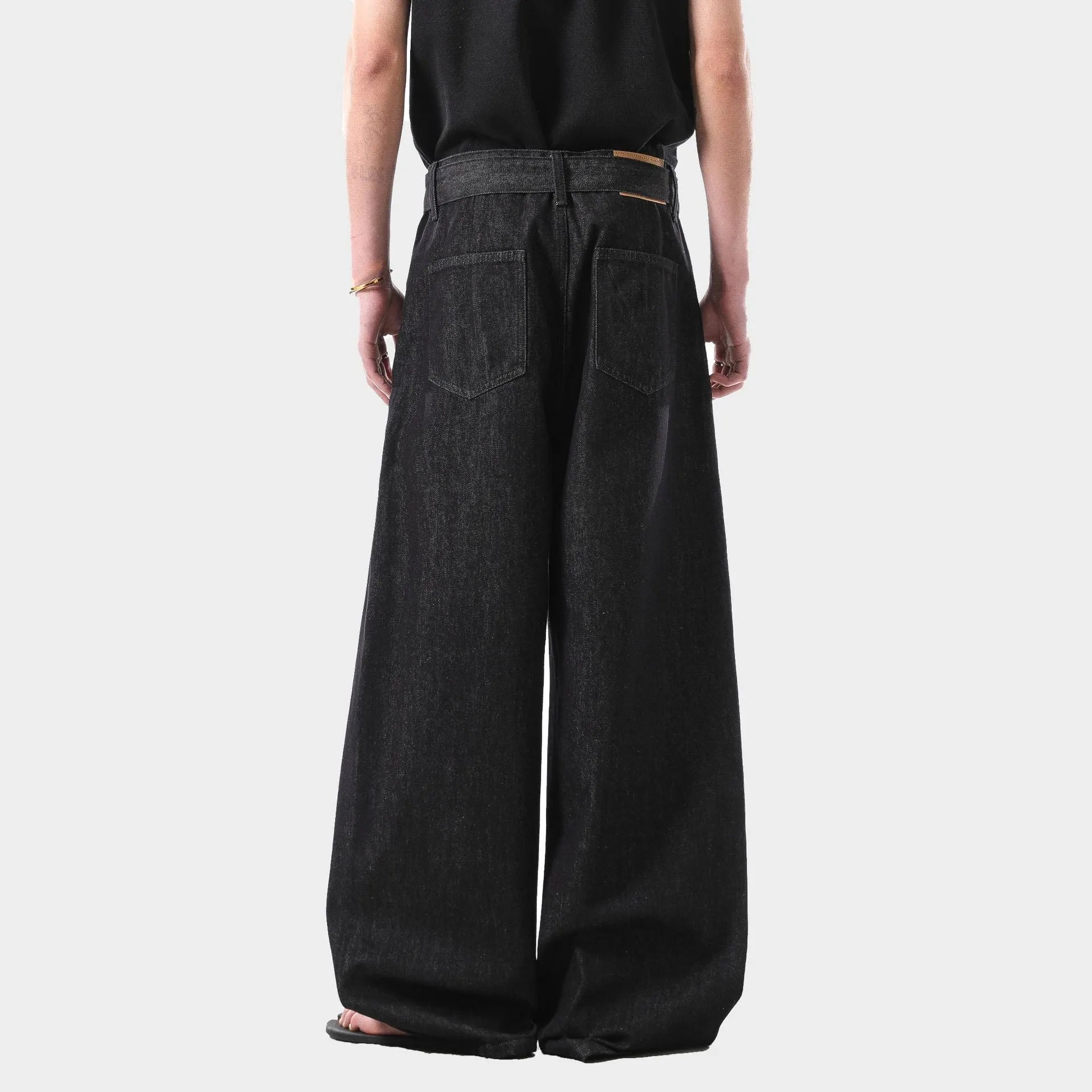Black straight leg jeans with high waist and subtle gold metallic details, zip fly fastening