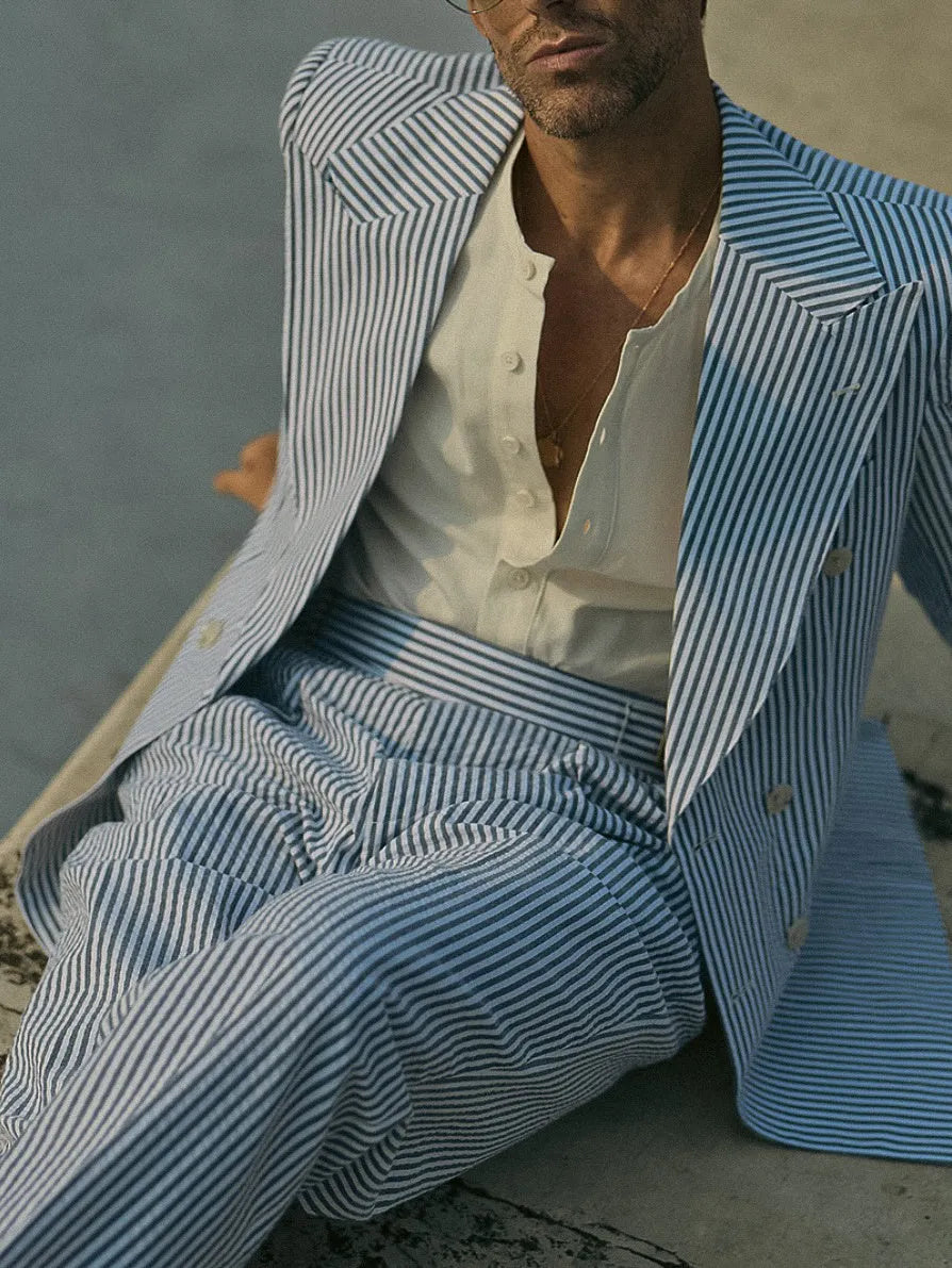 Blue and white striped polyester suit set with blazer and trousers on a hanger