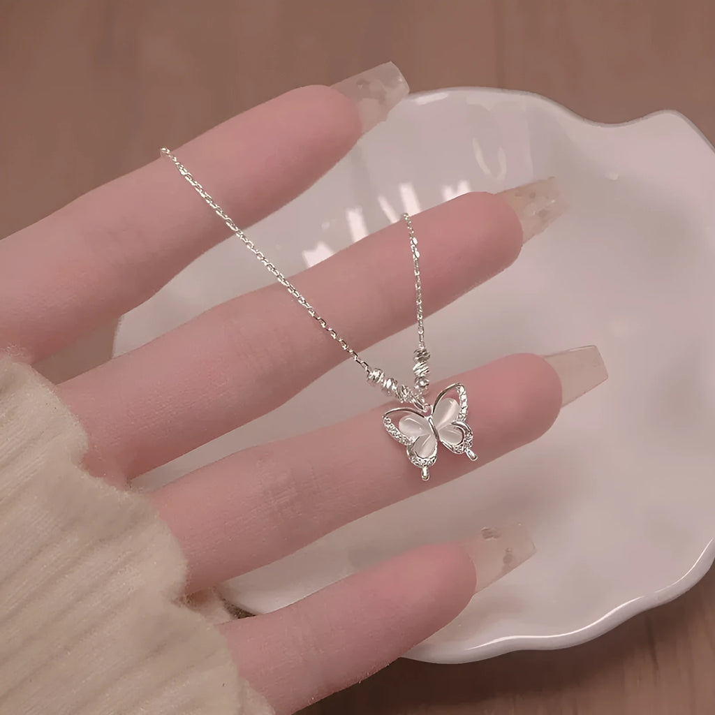 Close-up of a women's square line opal butterfly pendant on a silver adjustable cross chain necklace.