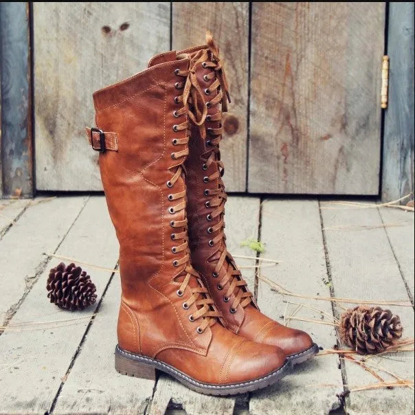 Women's black knight ankle boots with a cross strap detail on the front.