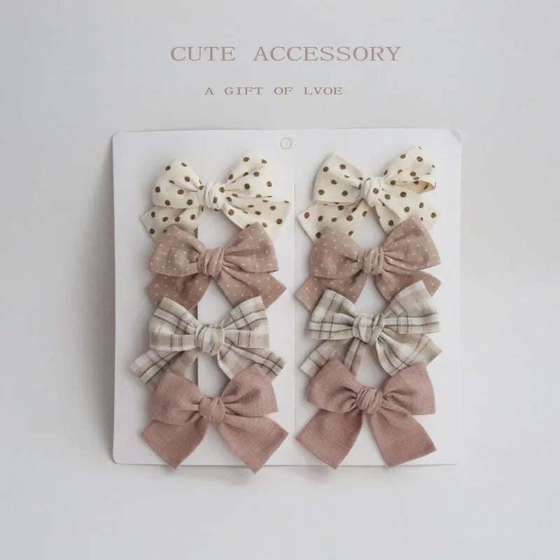 Set of children's cloth hair clips with a dovetail bow design in various colours.