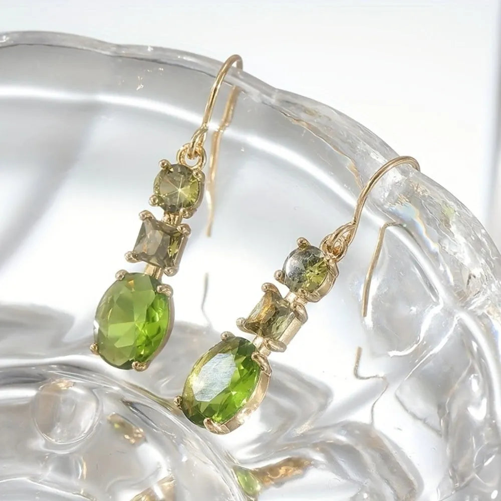 A pair of green square-shaped geometric copper drop earrings on a plain background.