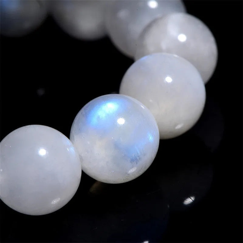 Natural blue polished moonstone round bead bracelet with adjustable clasp on a wrist.