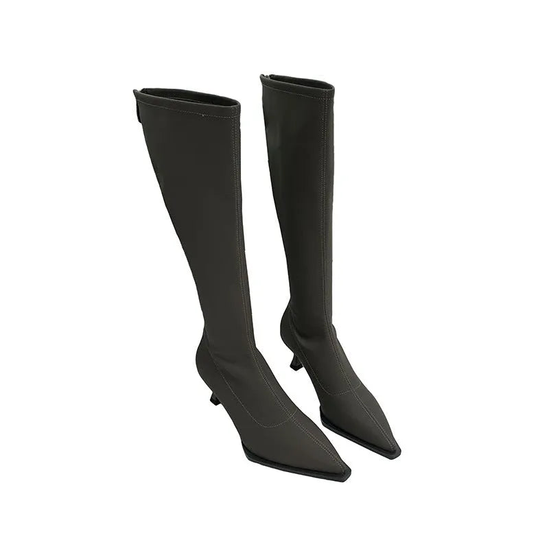 Black pointed toe below knee stiletto heel boots with a back zip, shown on a foot.