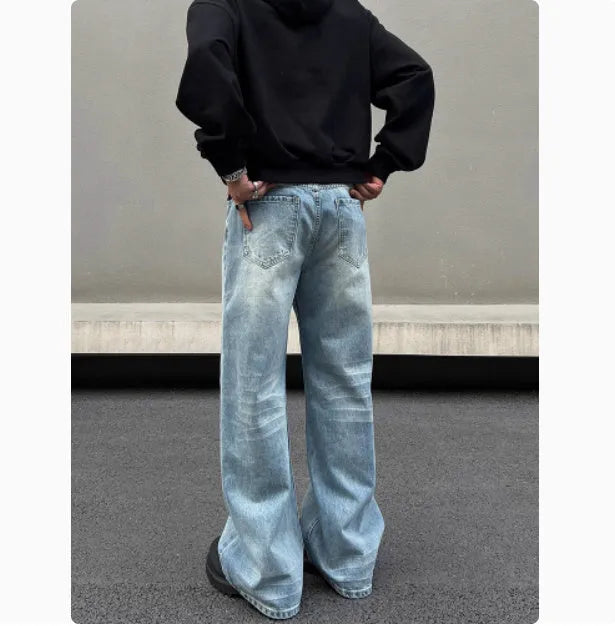 Men's blue retro straight-leg jeans with whisker washing detail on the thighs, showing a flared wide-leg cut.