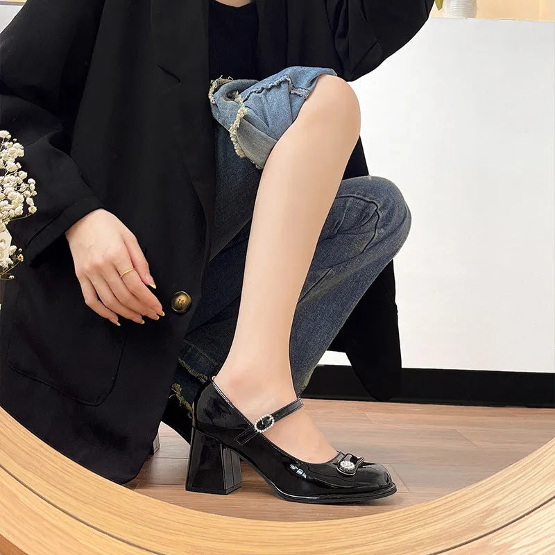Women's black patent leather chunky heel high shoes with round toe and buckle.