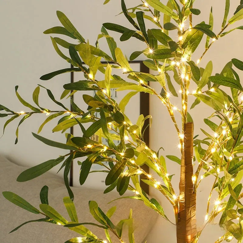Tall 1.8m artificial olive tree lamp with warm white LEDs illuminating simulation leaves in a courtyard setting.
