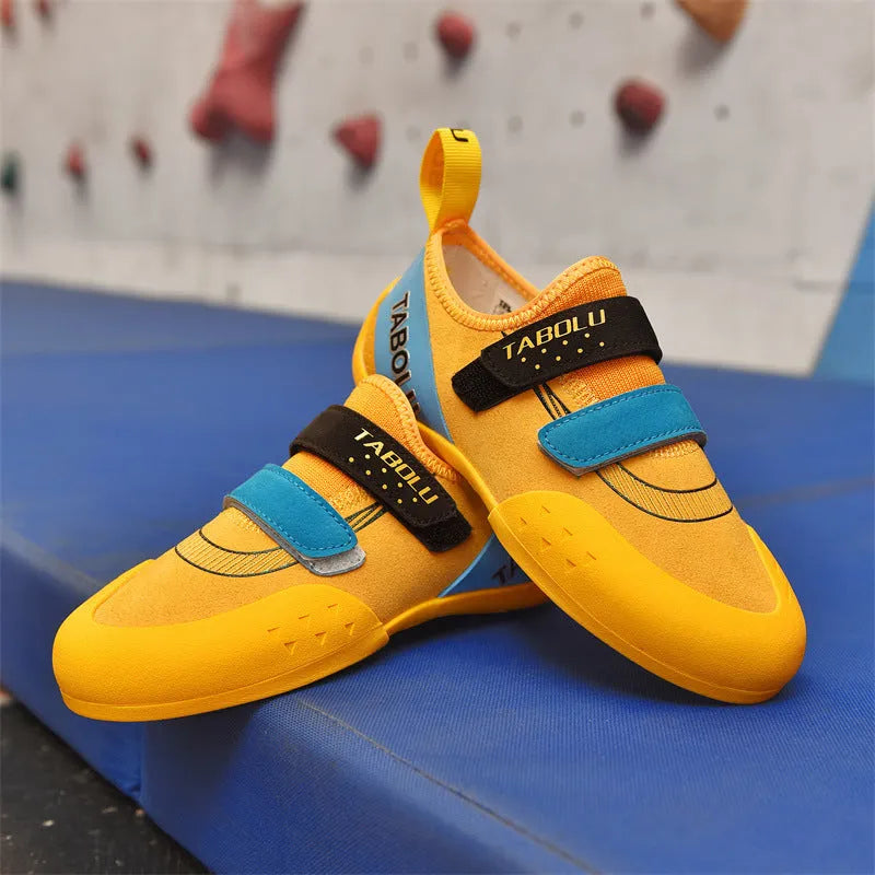 Beginner rock climbing shoes in black and red with Velcro strap and rubber sole.