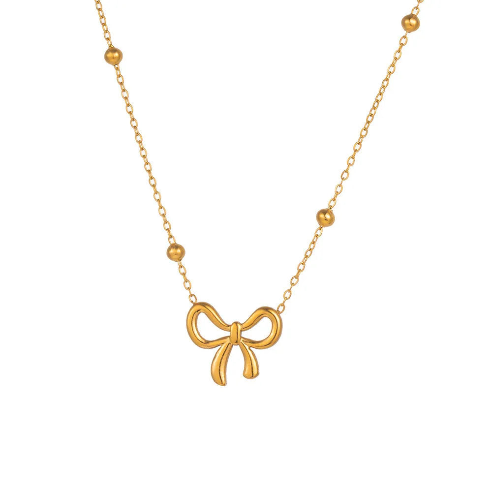 Gold titanium steel bow necklace on a cross chain, adjustable between 41cm and 50cm.